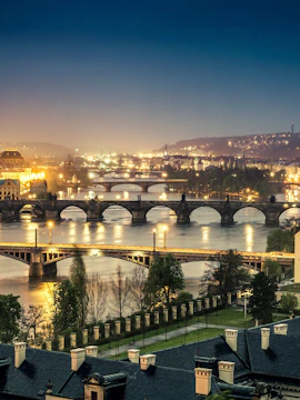 Charles Bridge over Vltava River in Prague with tourists exploring historic architecture.