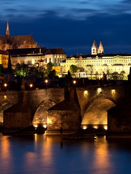 Prague ghost tour guide leading group through historic Old Town at night.