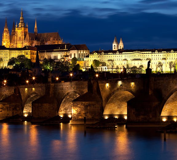 Prague ghost tour guide leading group through historic Old Town at night.