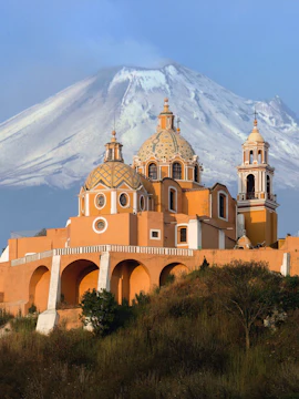 Puebla Cholula pyramid with volcano backdrop on Mexico City to Puebla tour.