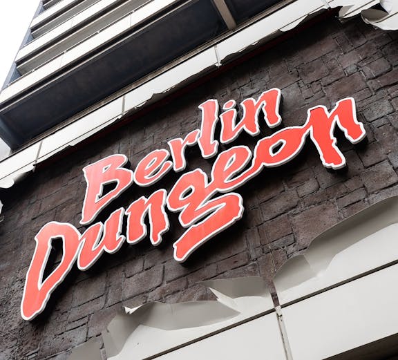 Berlin Dungeon entrance with historical architecture and tourists gathered outside.