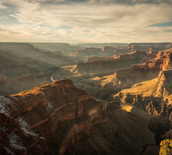 Grand Canyon view with layered rock formations under clear sky, tour from Las Vegas.