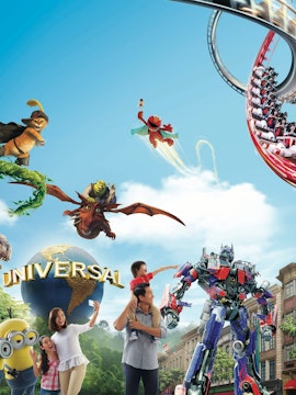 Universal Studios Singapore entrance with iconic globe and visitors exploring the theme park.