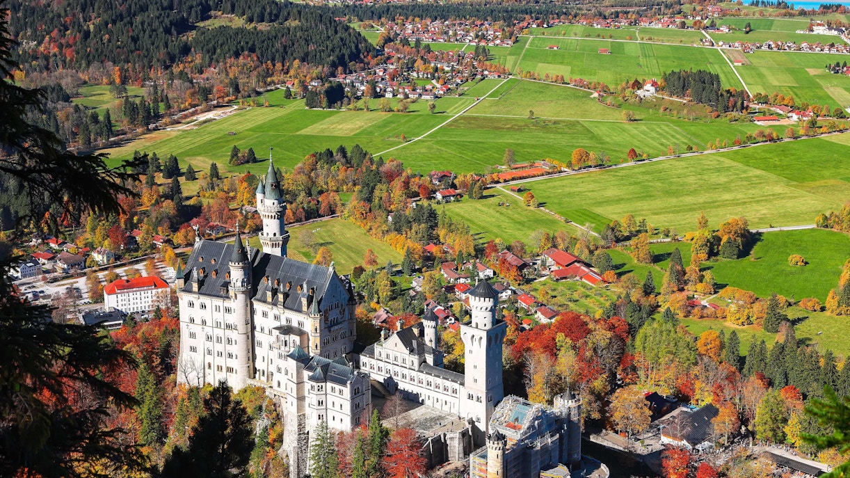 Neuschwanstein Castle in Bavaria with guided tour group exploring the exterior.