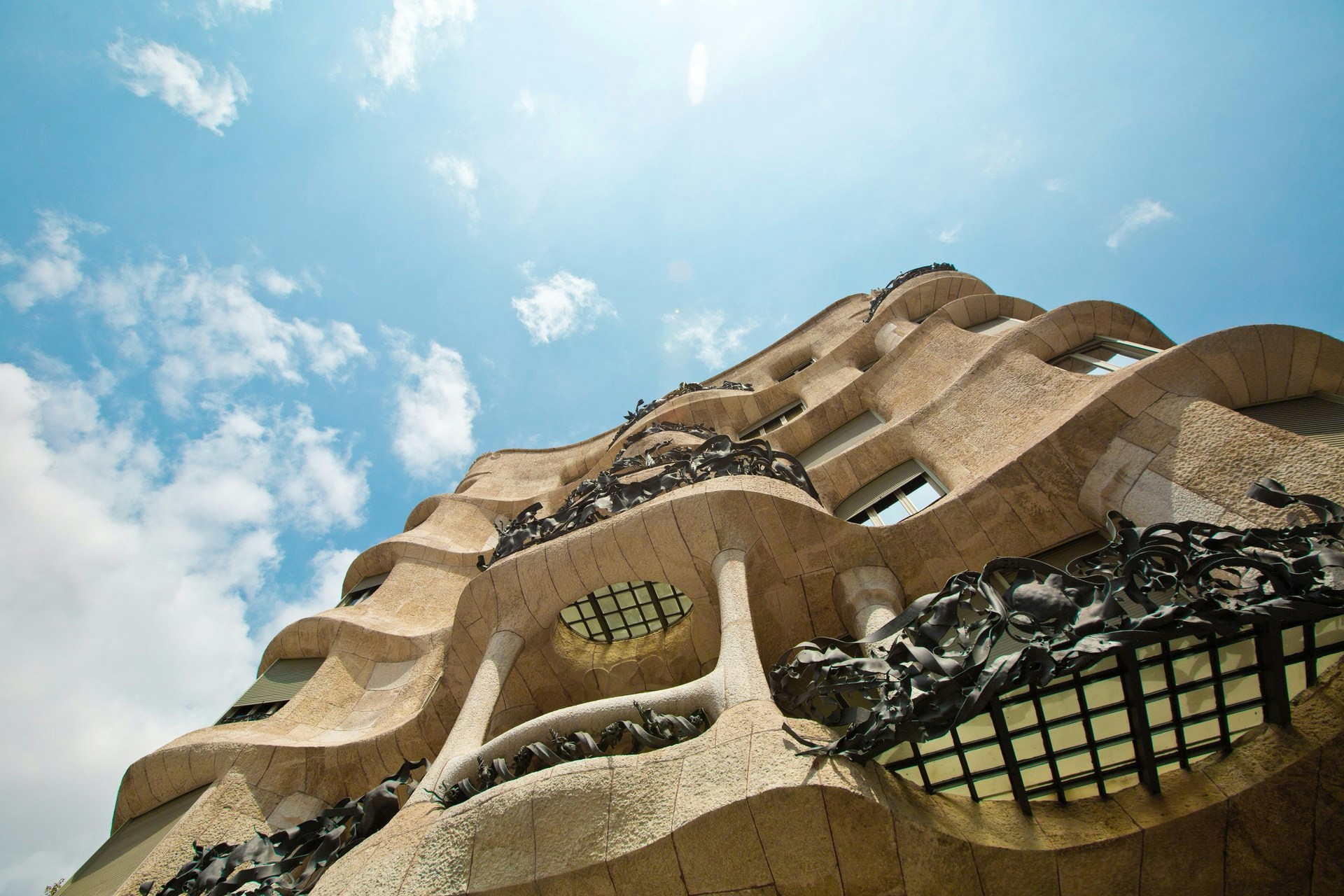 Casa Mila rooftop with unique chimneys and Barcelona cityscape in the background.