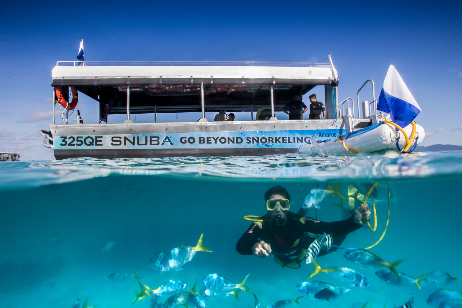 Tourists enjoying a Green Island cruise with a view of the lush coastline and clear blue waters.