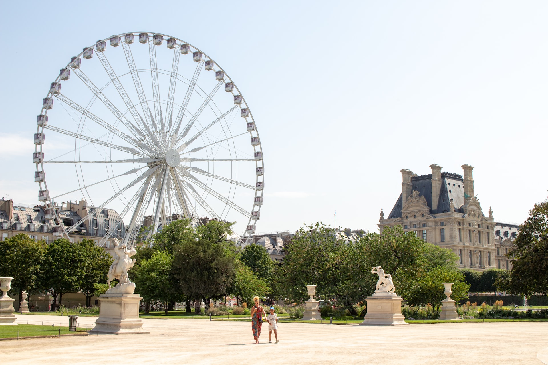 Jardin des Tuileries in Paris with family strolling along tree-lined paths.