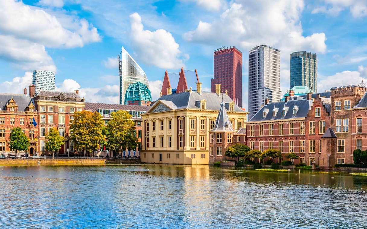 Historic buildings and modern skyscrapers by a canal in The Hague, Netherlands.