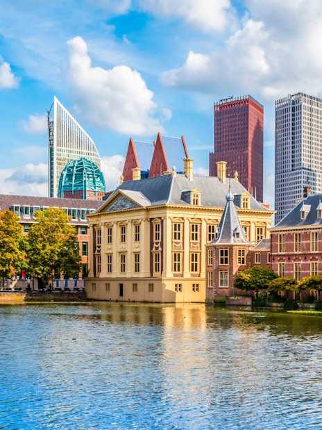 Historic buildings and modern skyscrapers by a canal in The Hague, Netherlands.