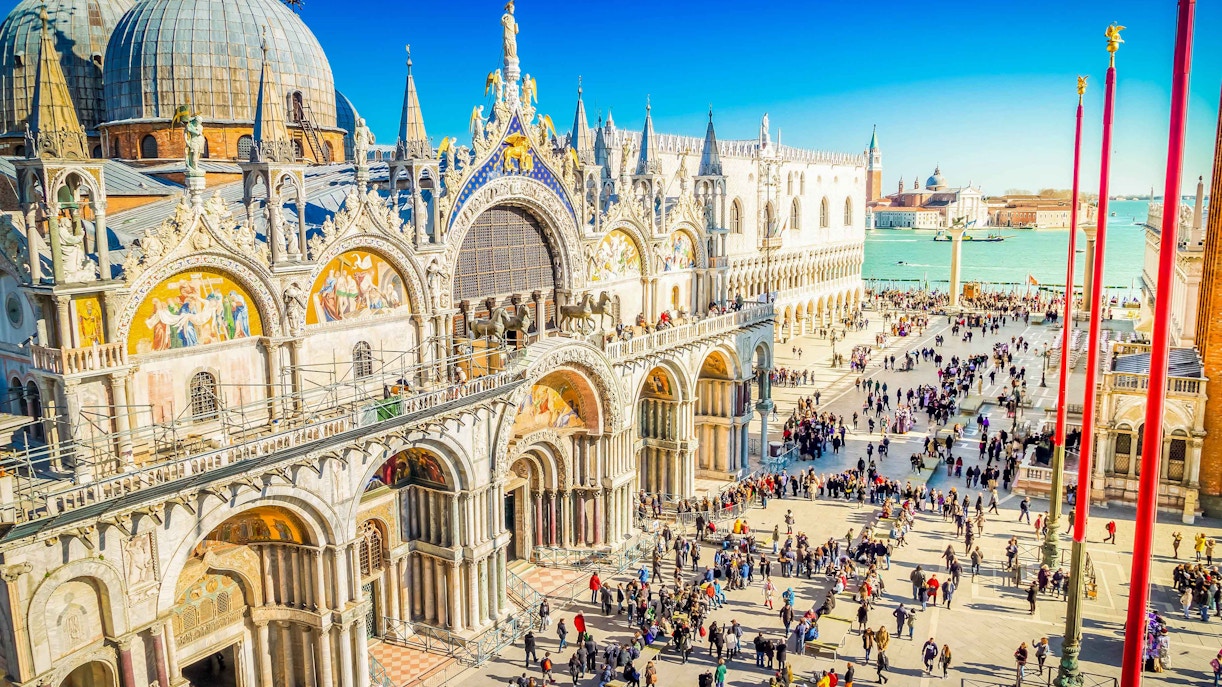 St. Mark's Basilica in Venice with crowds in the square, view of the Grand Canal.