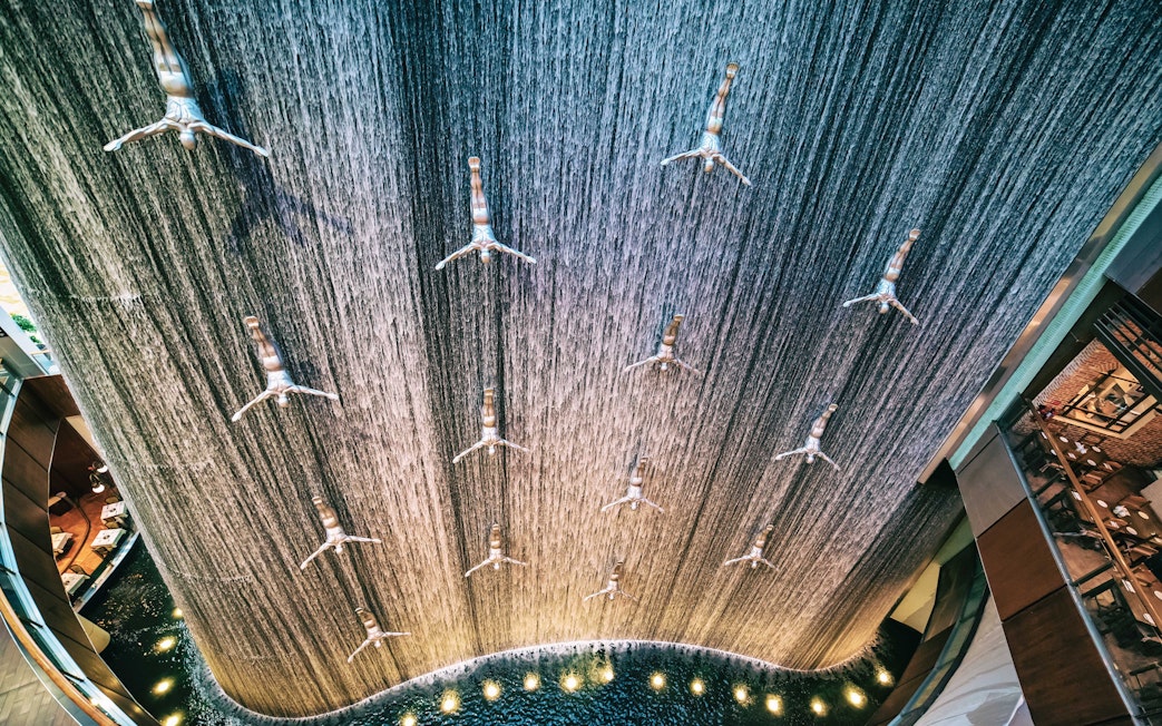 Waterfall installation with diving sculptures at Dubai Mall.