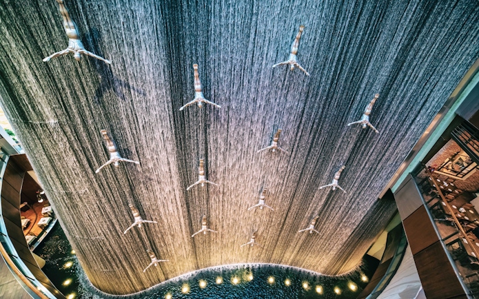 Waterfall installation with diving sculptures at Dubai Mall.
