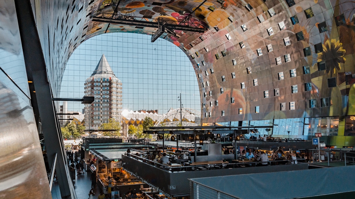 Foodhallen Amsterdam indoor market with diverse food stalls and visitors dining.