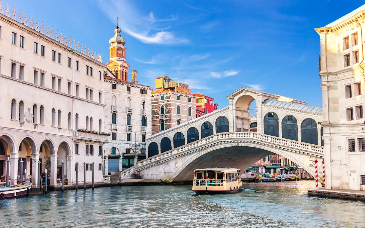 Boat passing under the Rialto Bridge on a Venice canal tour.