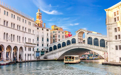 Boat passing under the Rialto Bridge on a Venice canal tour.
