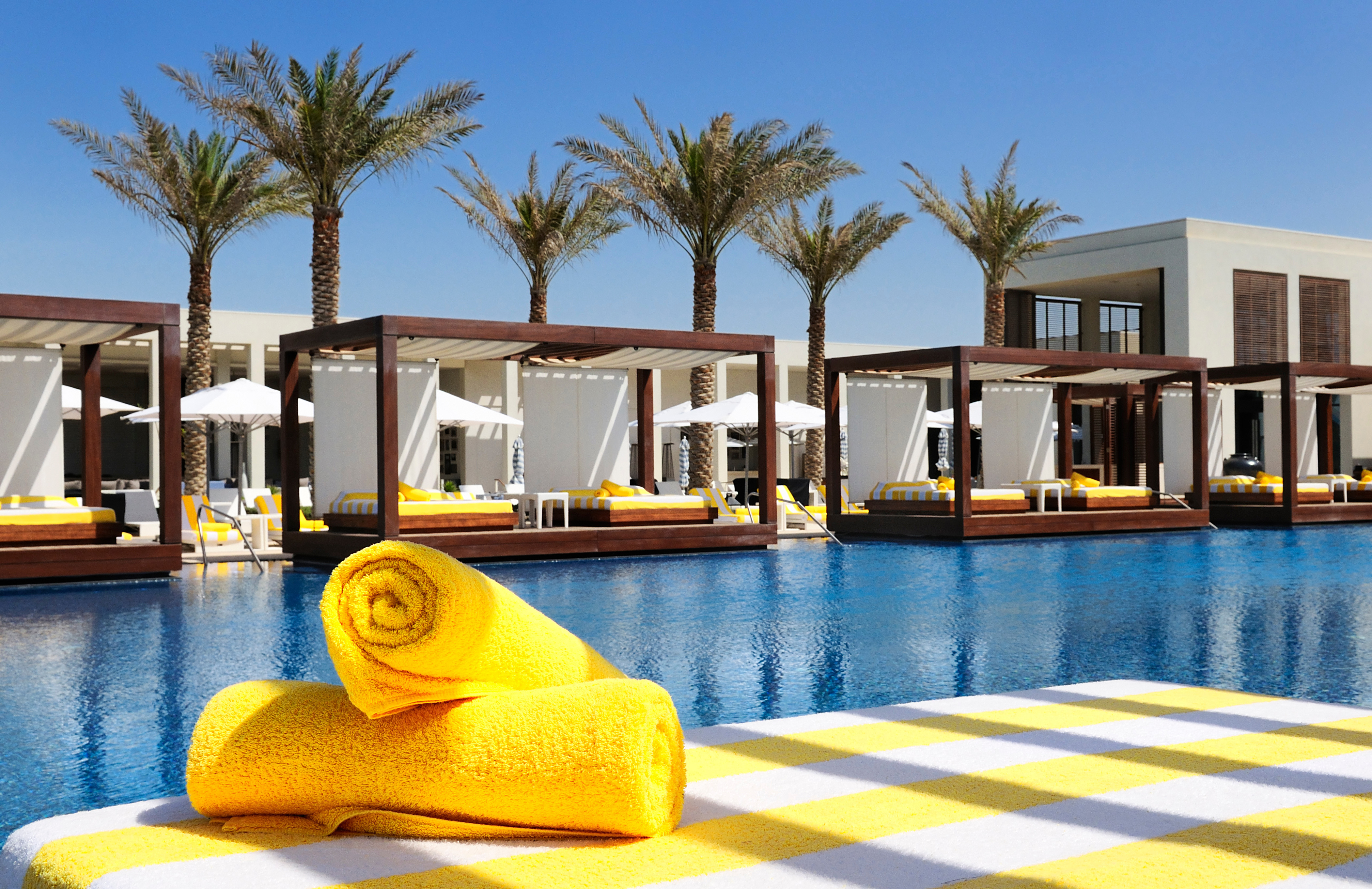 Poolside cabanas with yellow towels at Dubai Mall.