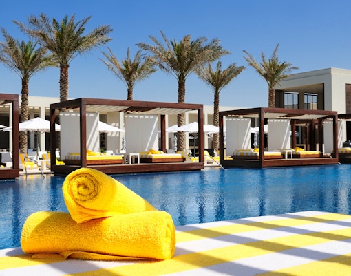 Poolside cabanas with yellow towels at Dubai Mall.