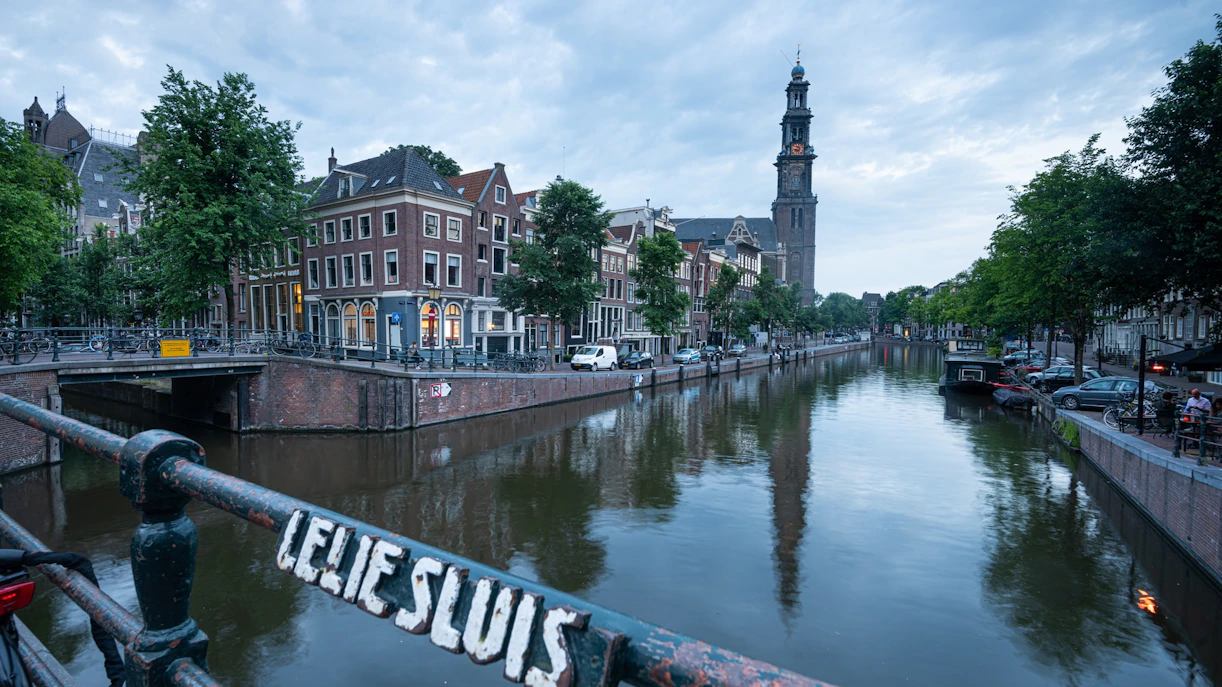 Canal view in Jordaan, Amsterdam with Westerkerk tower in the background.