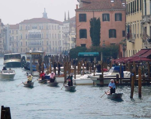Rowers in traditional costumes on Venice's Grand Canal during Befana Regatta in January.