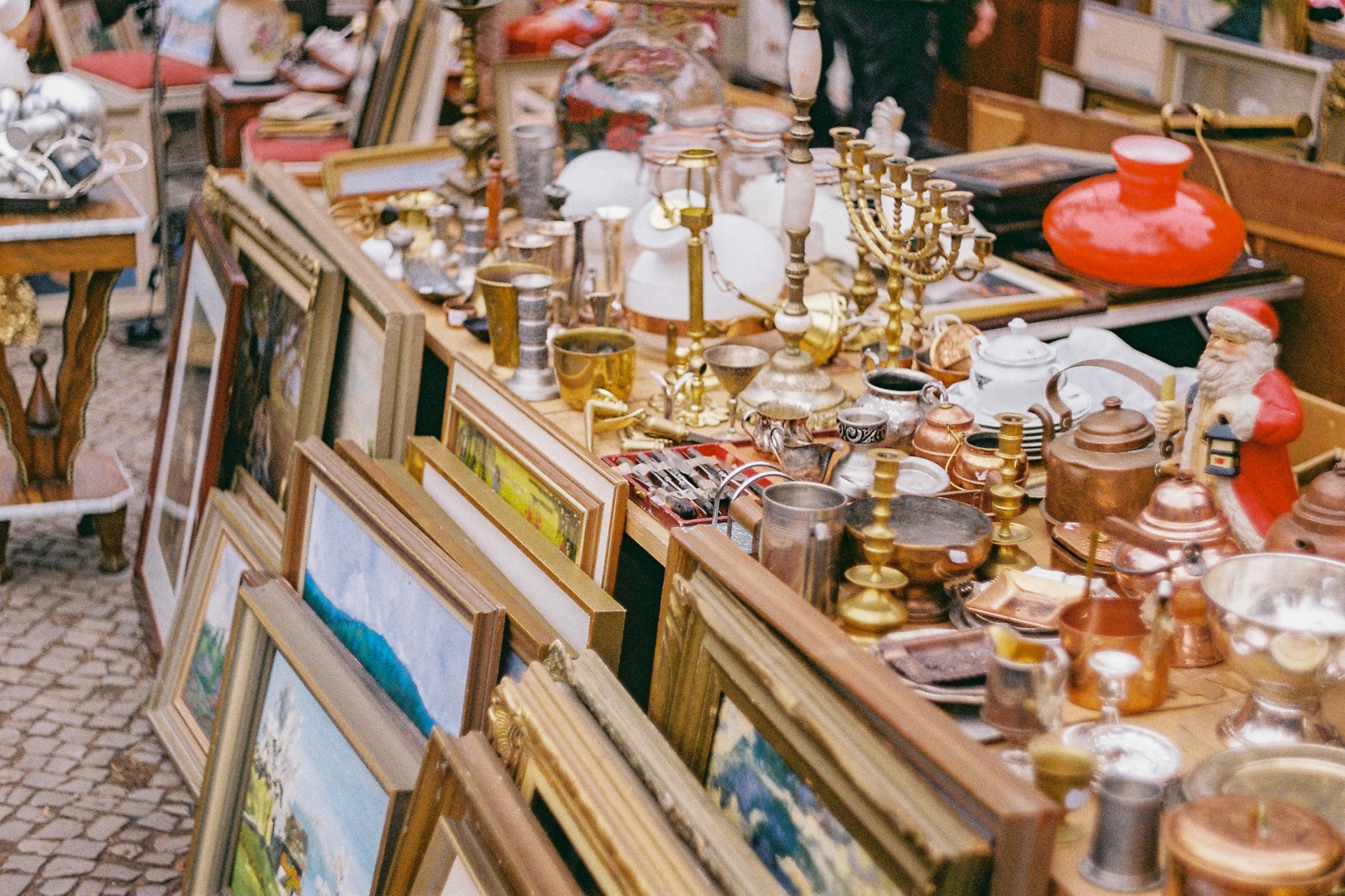 Antique items and paintings displayed at a flea market in Athens.