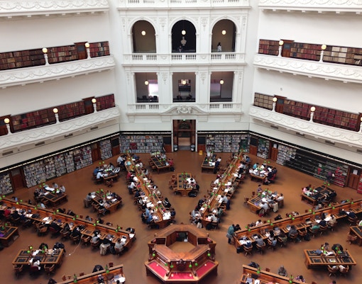 State Library of Victoria reading room with people studying at long tables.