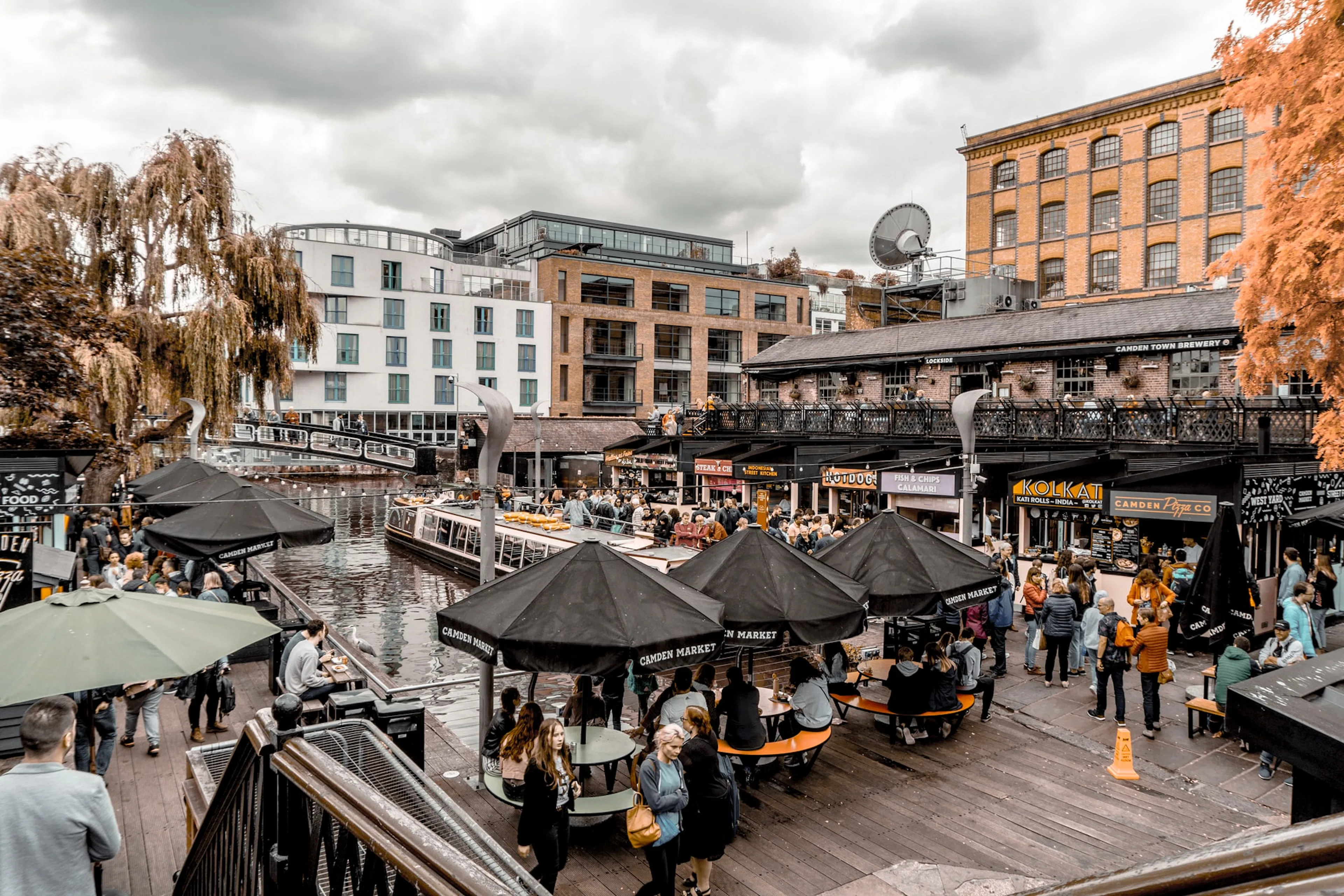 Camden Market by the canal in London, bustling with people and outdoor seating.