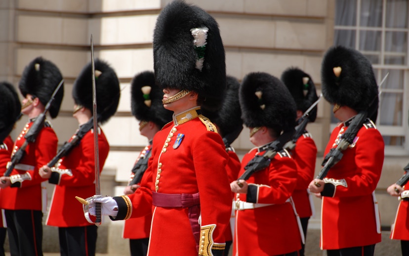 British guards in red uniforms and bearskin hats during a ceremonial event.