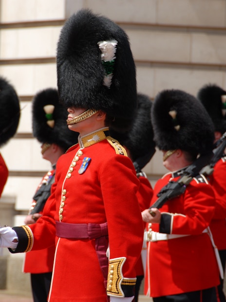 British guards in red uniforms and bearskin hats during a ceremonial event.