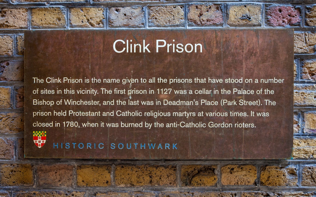 Clink Prison sign detailing its history, featured on a Harry Potter film location tour during a Thames Boat Cruise.