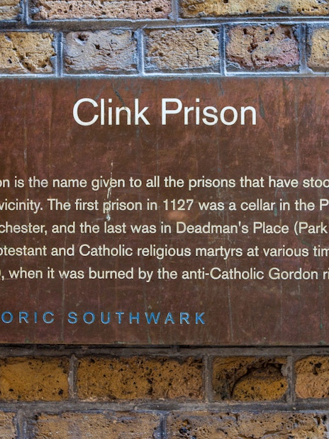 Clink Prison sign detailing its history, featured on a Harry Potter film location tour during a Thames Boat Cruise.