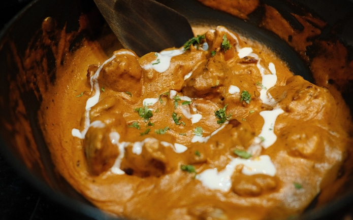 Butter chicken dish with creamy sauce and herbs, related to Temple of Olympian Zeus tour.