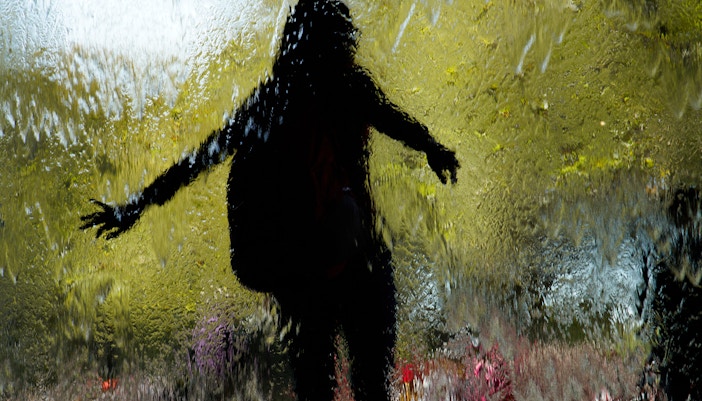 Silhouette of a person behind a water feature at Melbourne's Federation Square.