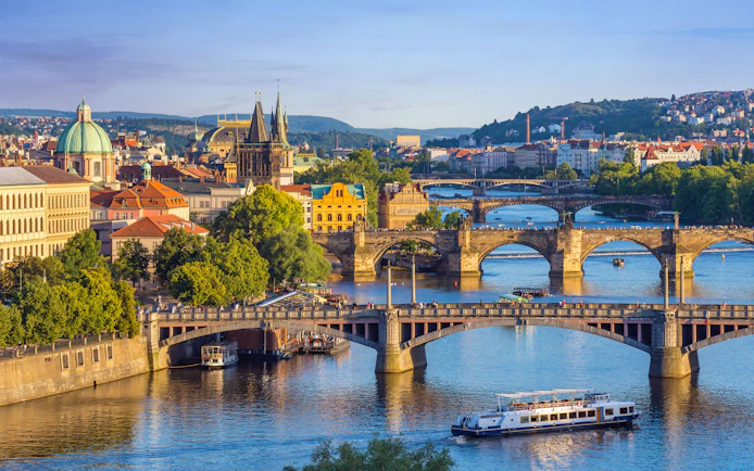 Charles Bridge with tourists walking towards Prague Castle in Prague Old Town.