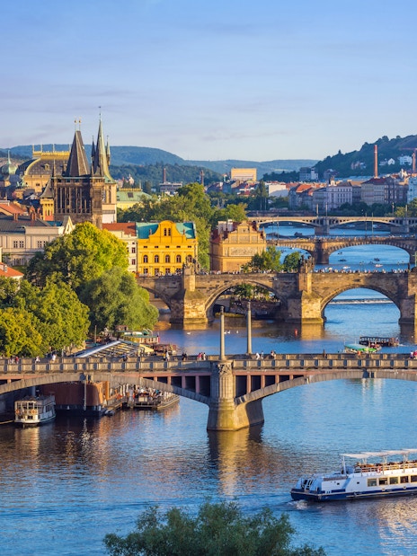 Charles Bridge with tourists walking towards Prague Castle in Prague Old Town.
