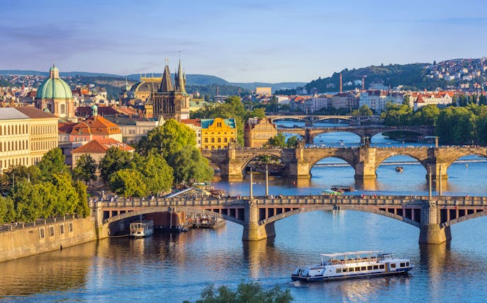 Charles Bridge with tourists walking towards Prague Castle in Prague Old Town.