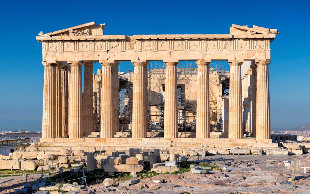 Parthenon at Acropolis, Athens, Greece, viewed from the front with ancient ruins in foreground.