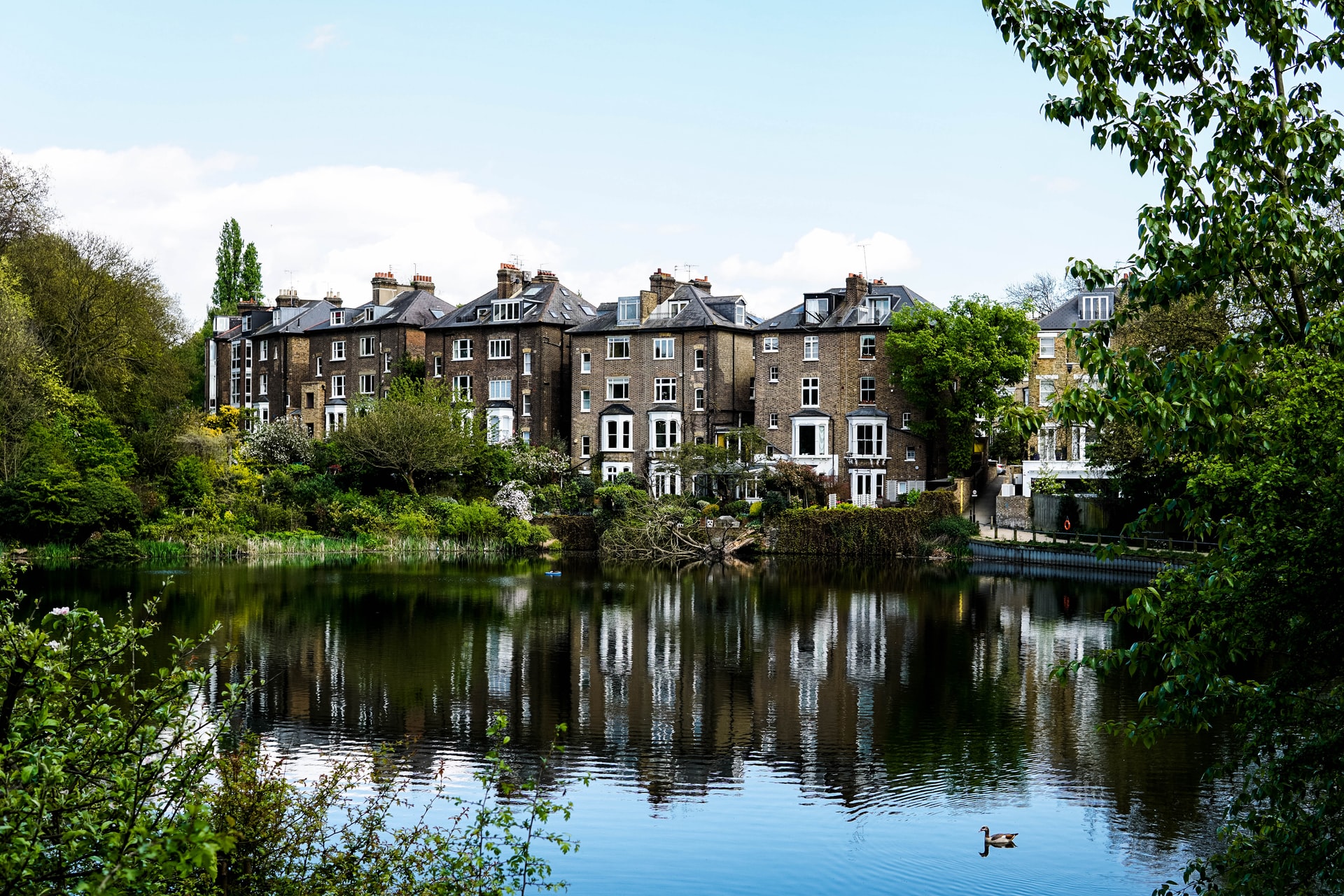 Hampstead Heath view of London skyline with lush greenery in foreground.