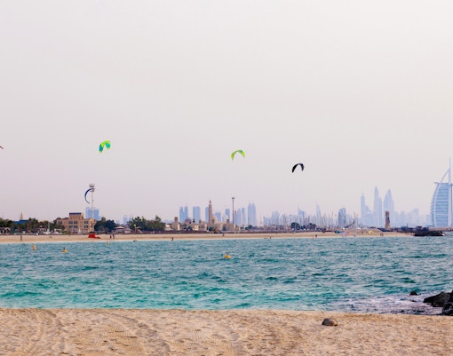 Kite surfers enjoying waves at Kite Beach, Dubai, UAE.