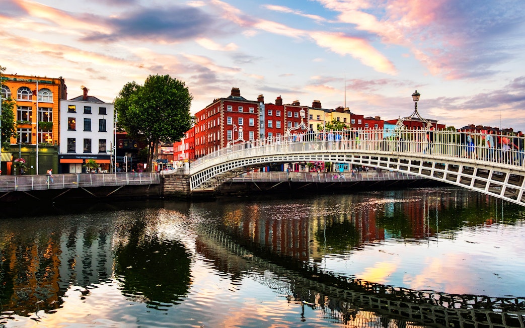Ha'penny Bridge over River Liffey in Dublin, Ireland at sunset.