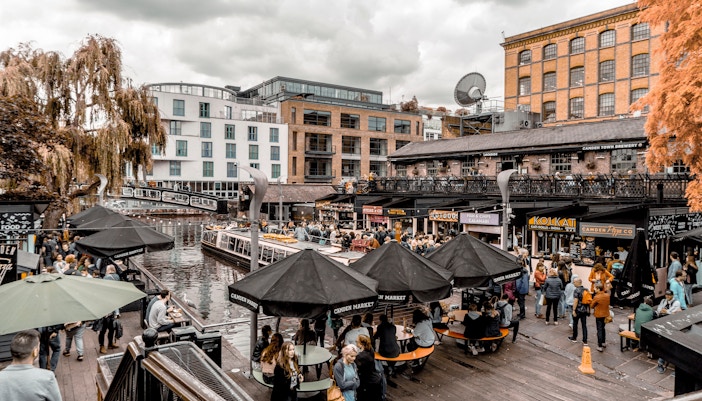 Crowds enjoying food and shopping at Camden Market by the canal in London.