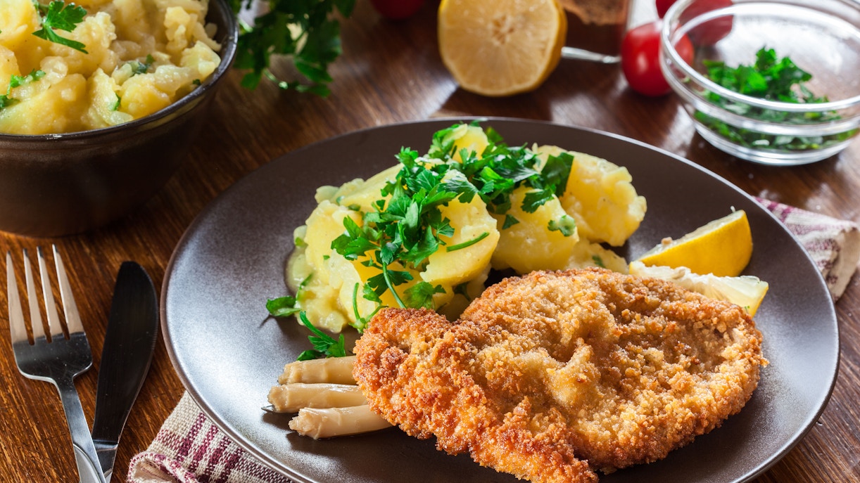 Traditional Austrian schnitzel served with lemon and parsley in Vienna restaurant.