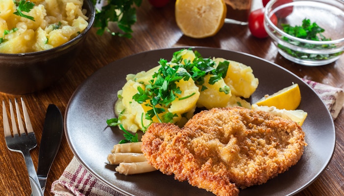 Traditional Austrian schnitzel served with lemon and parsley in Vienna restaurant.