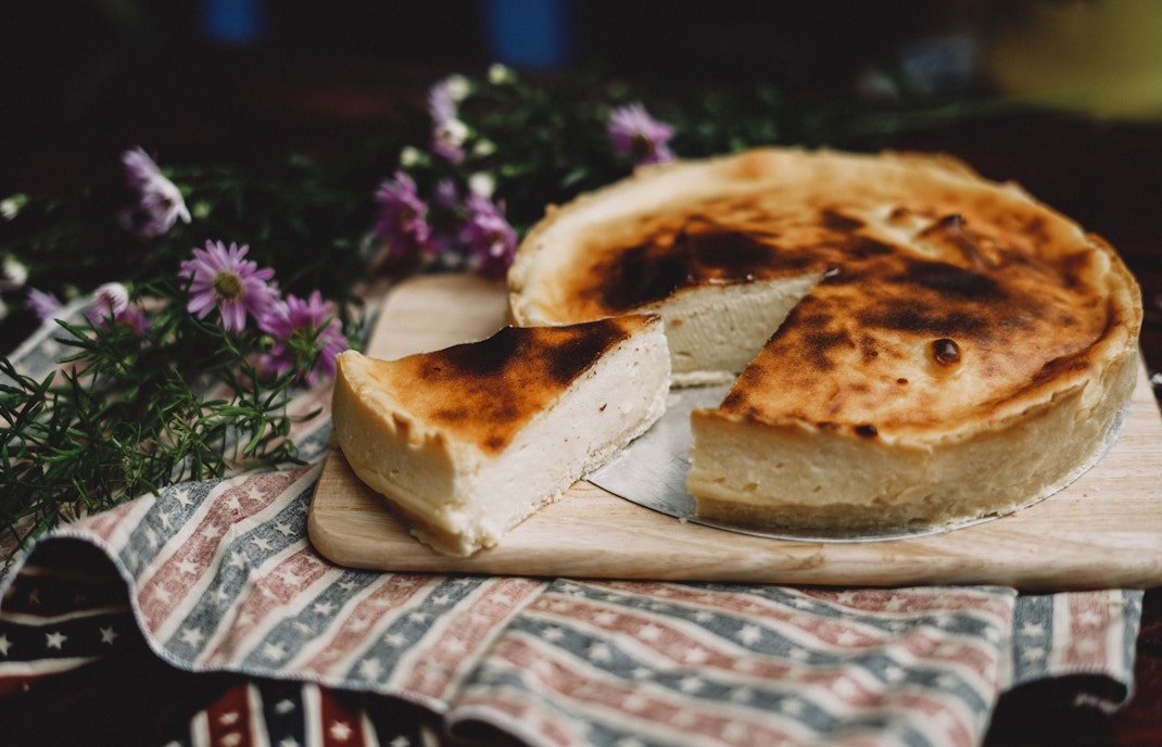 Cheesecake slice on a wooden board with flowers
