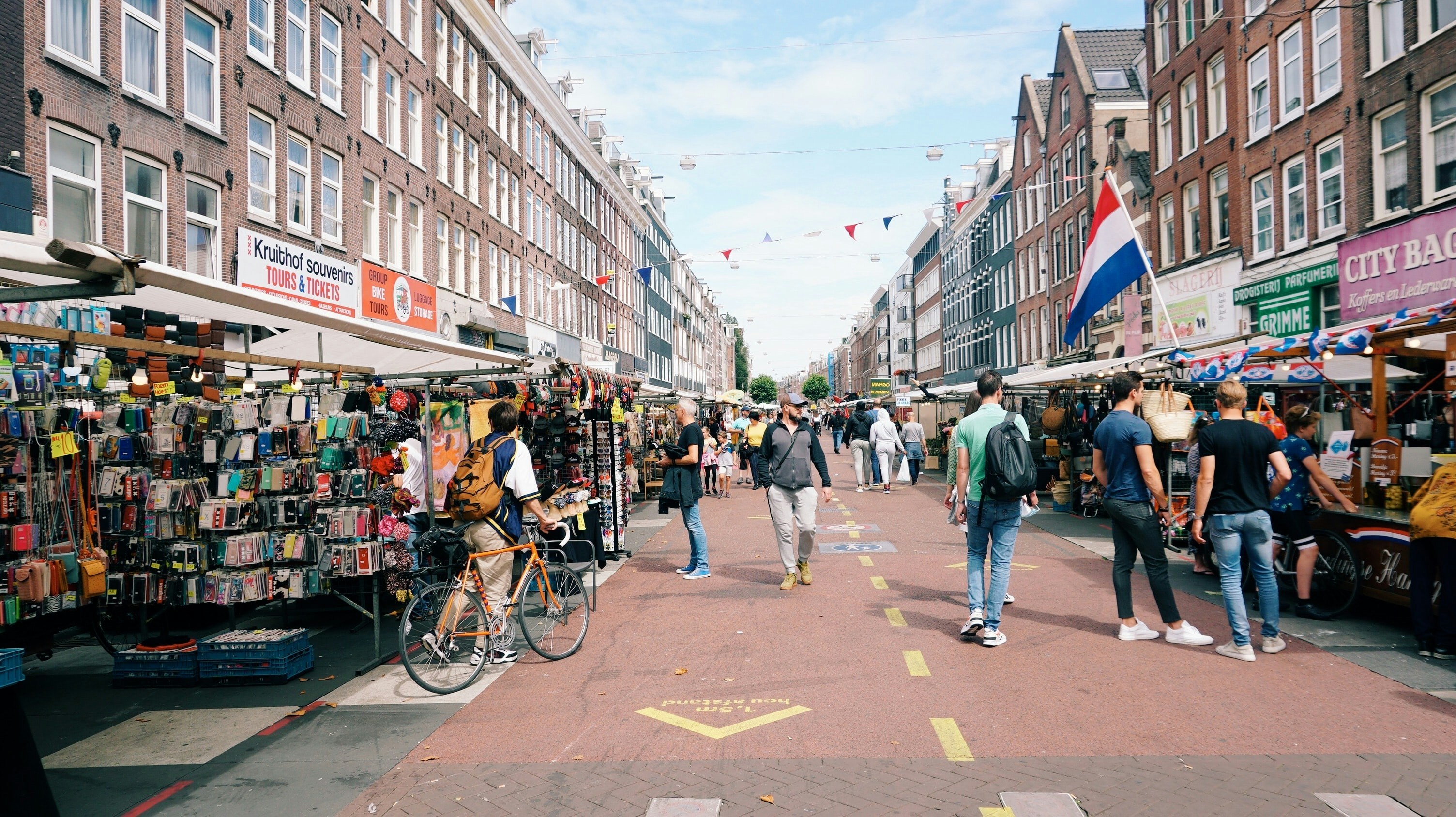 Albert Cuyp Market in Amsterdam with stalls selling souvenirs and people walking.