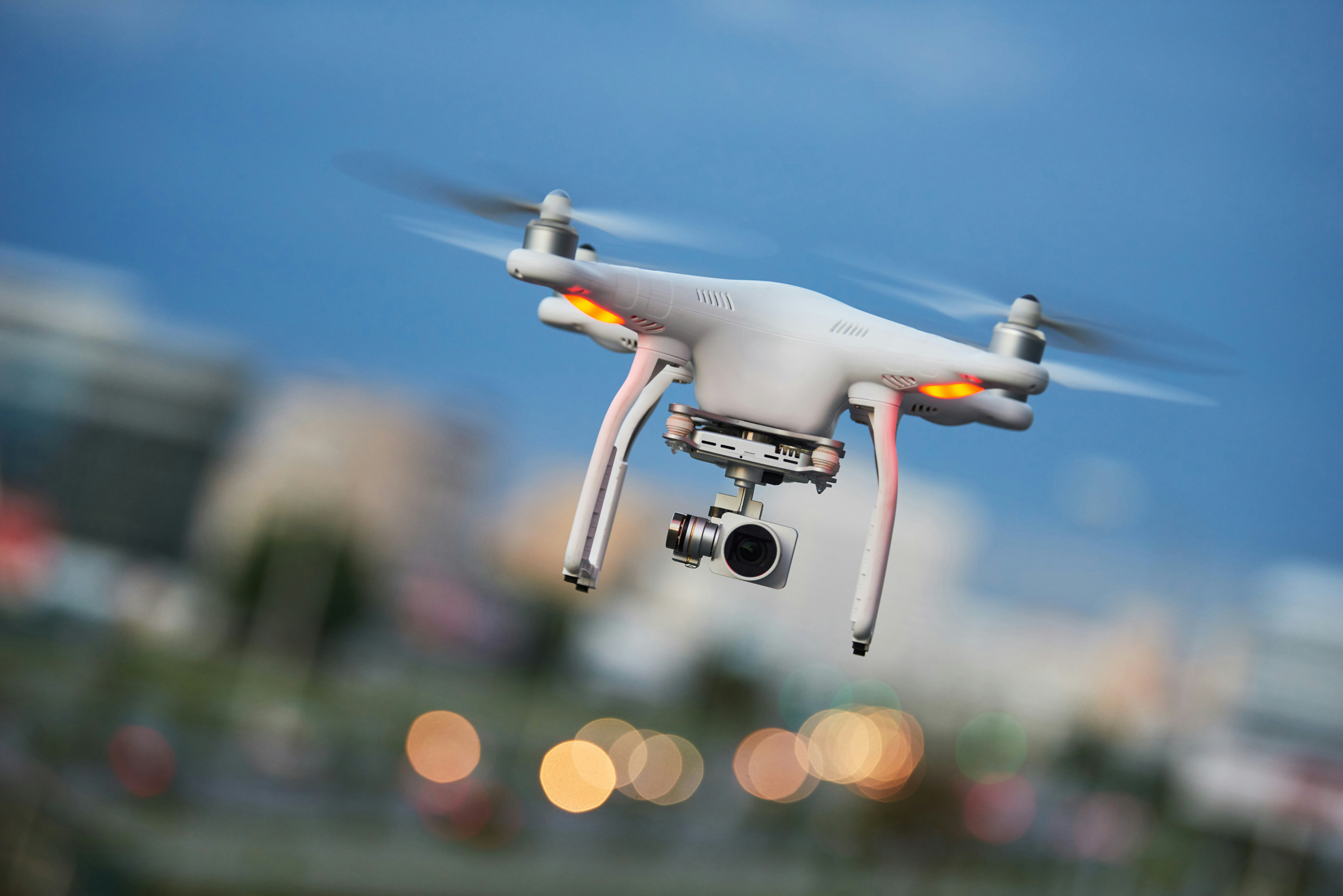 Drone flying with camera in urban setting.