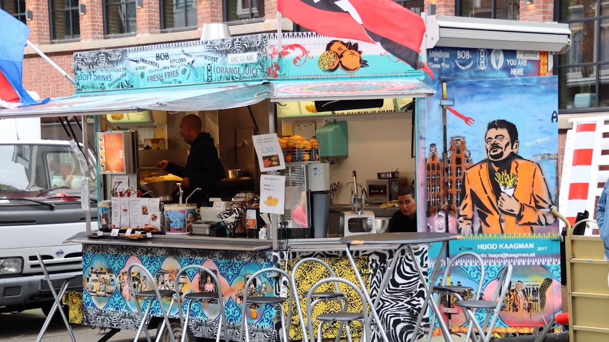 Albert Cuyp Market stalls with fresh produce and vibrant flowers in Amsterdam.