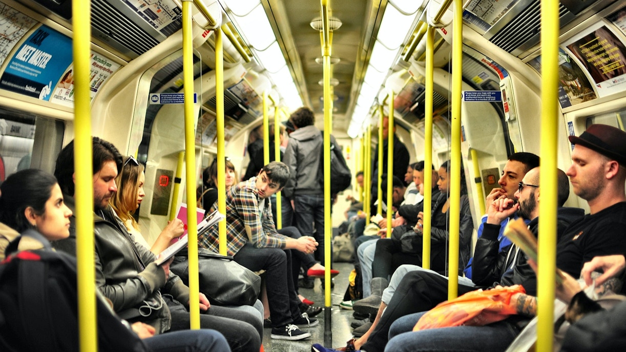Passengers seated inside a London Tube train.