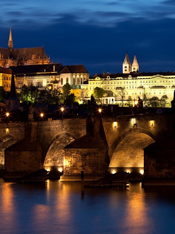 Prague ghost tour guide leading group through historic Old Town at night.