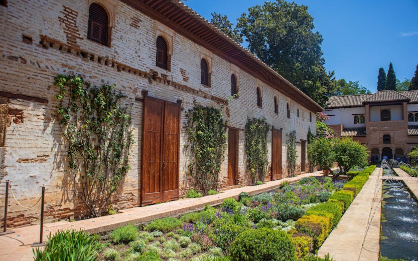 Generalife Gardens in Granada with lush greenery and historic architecture.