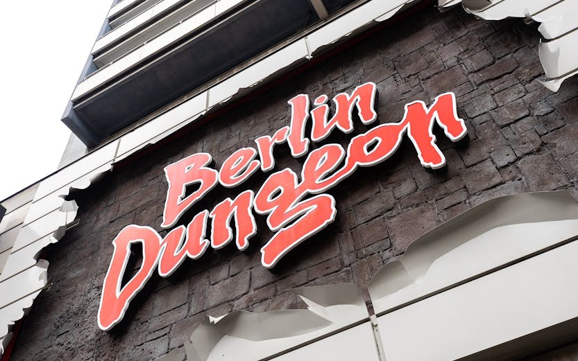 Berlin Dungeon entrance with historical architecture and tourists gathered outside.